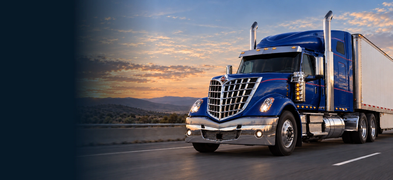 Blue International LoneStar sleeper-cab truck hauling a white trailer on a highway at sunrise.